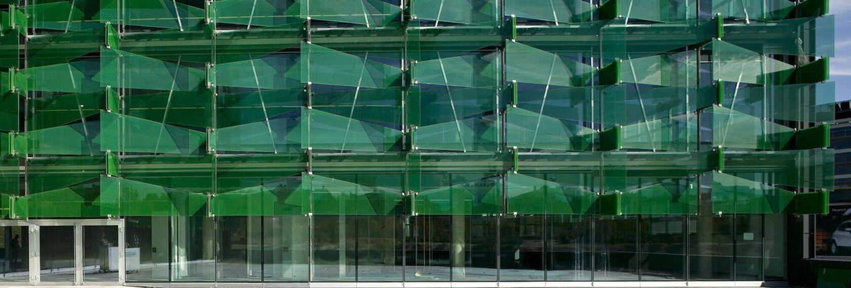 Green glass façade of the Coca-Cola Headquarters in Madrid, Spain.