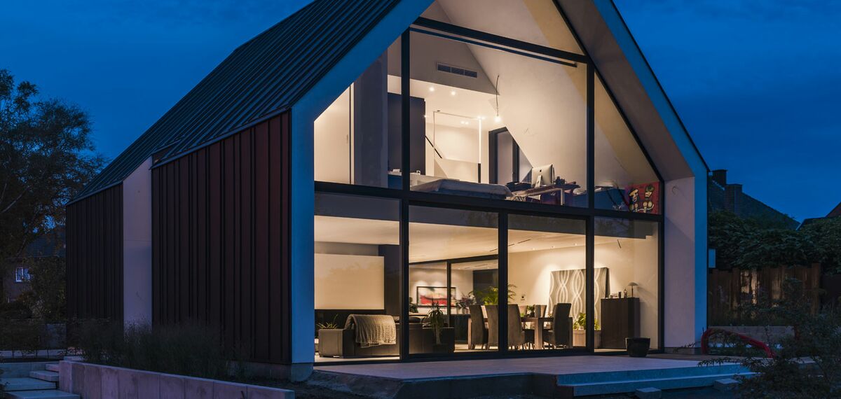 “Exterior nighttime view of private home in Bilzen, Belgium.